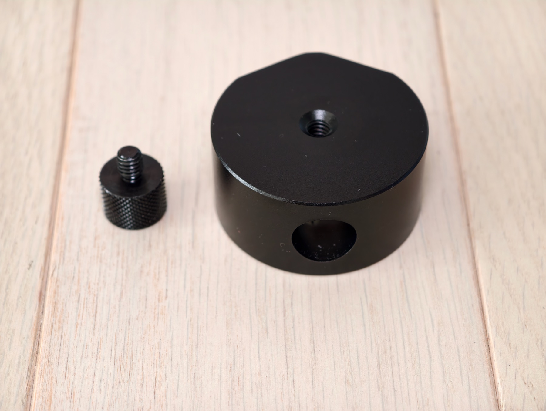 WEYLCORE tripod mount adapter base and compact clearance riser on a light wood surface.